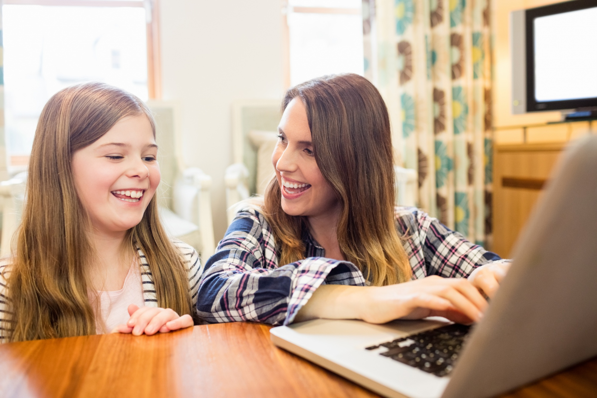 Mother and daughter working together at a desk during a homeschool lesson